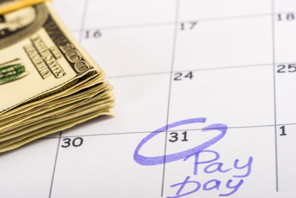 selective focus of dollar banknotes, calendar with marked number 31 and 'pay day' lettering - Photo, Image