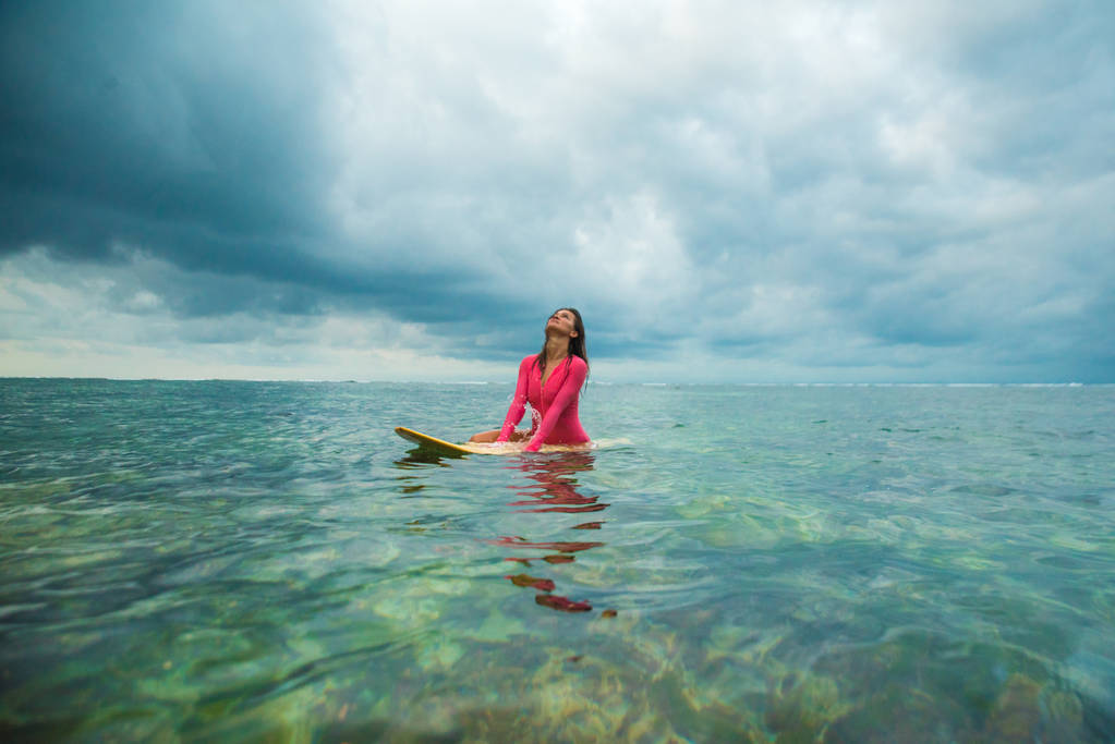Mooie vrouw zwemt op een surfplank. - Foto, afbeelding