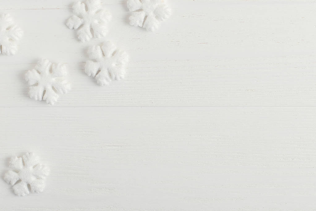 Copos de nieve blancos en una mesa de madera. Concepto de Navidad en colores brillantes. Copiar espacio
. - Foto, imagen