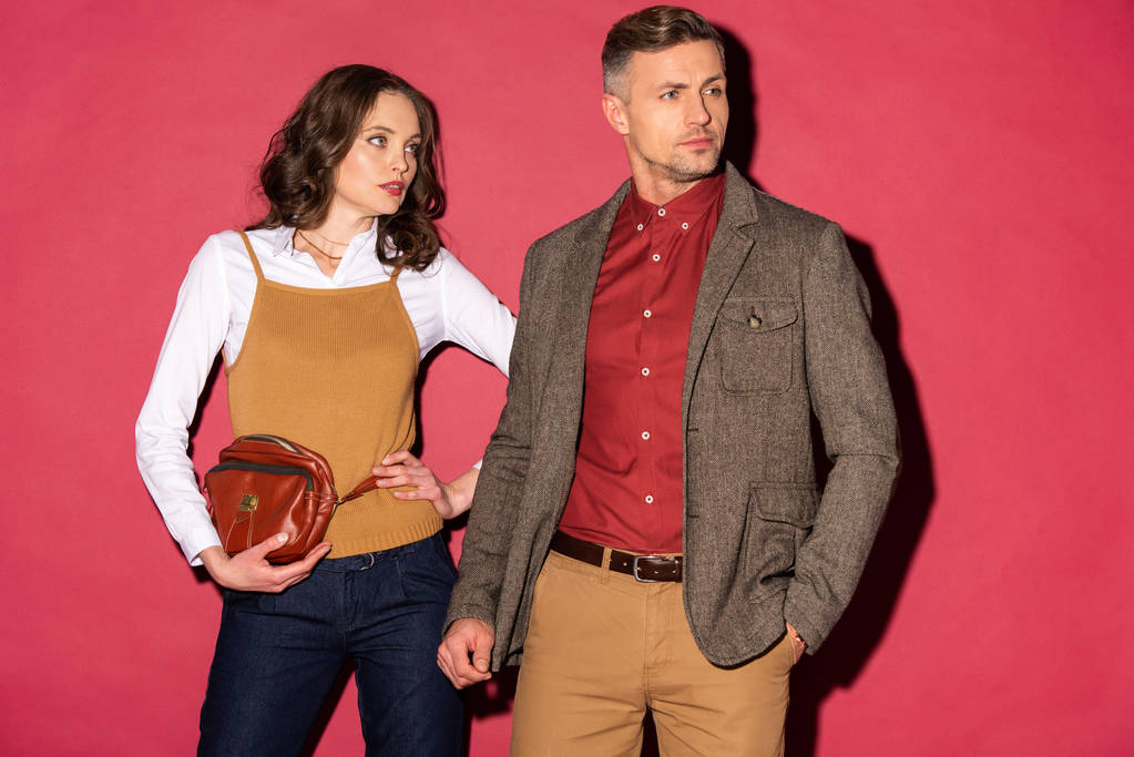 schönes stylisches Paar in formaler Kleidung posiert auf rotem Hintergrund - Foto, Bild