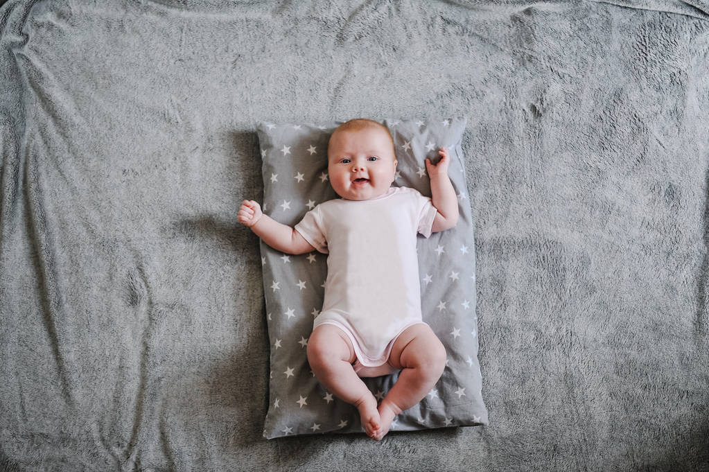 Niña bebé acostado en cuadros grises cálidos
 - Foto, Imagen