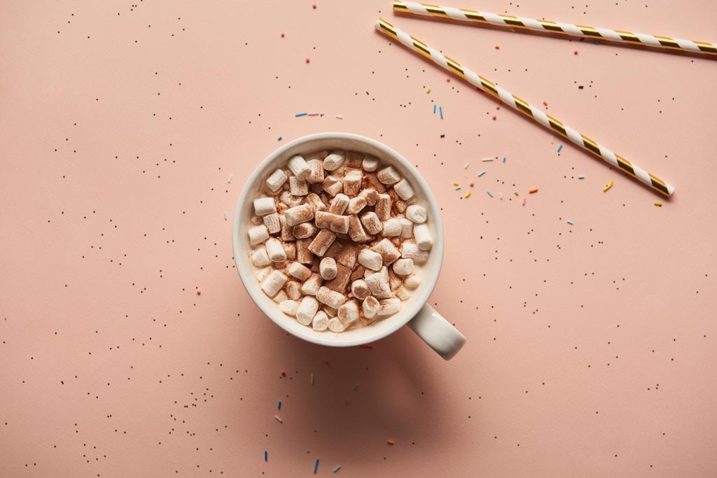 pohled shora Sladká kakaová s marshmallows u candy hole na růžovém pozadí  - Fotografie, Obrázek