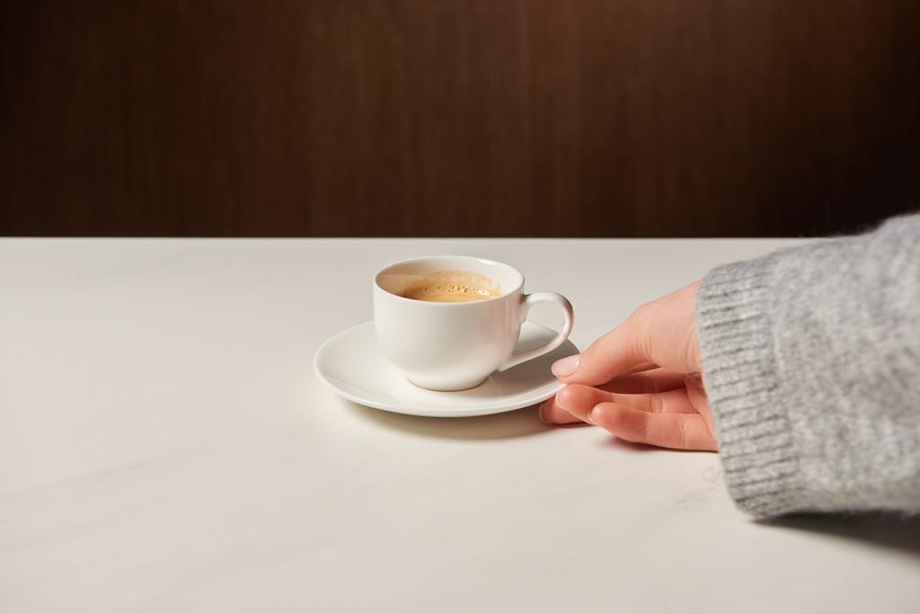 обрізаний вид жінки, що тримає чашку з гарячою кавою
 - Фото, зображення