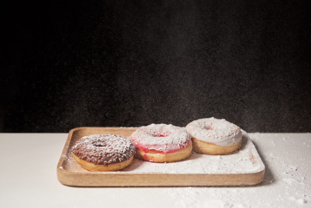 delicious donuts with sifting sugar powder on wooden cutting board - Photo, Image