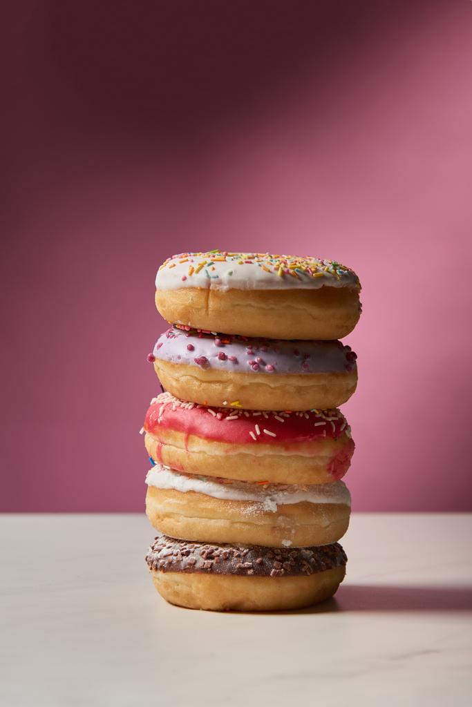 rosquillas esmaltadas dulces sobre fondo rosa
  - Foto, Imagen