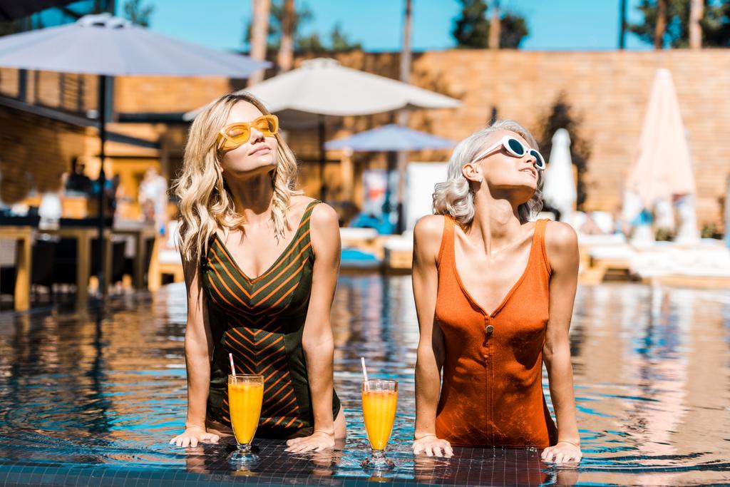 attraente donne alla moda relax in piscina con cocktail
 - Foto, immagini