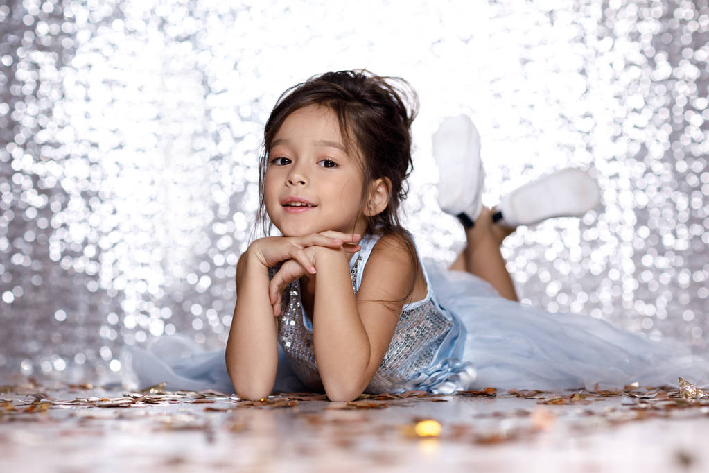 little girl in blue dress sitting on the floor with confetti - Photo, Image