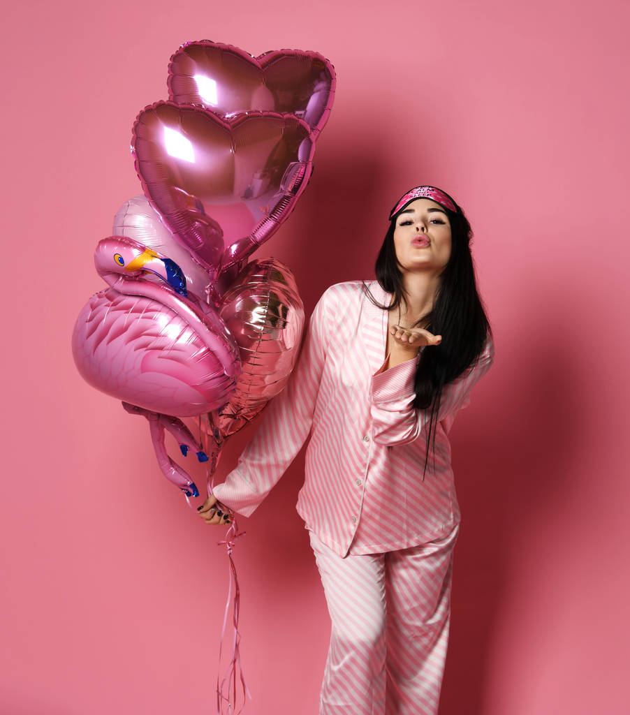 Valentine schoonheid meisje houdt rode en roze lucht ballonnen blazen kus op roze achtergrond Viering Valentines Day - Foto, afbeelding