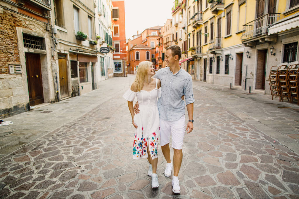 Piękna Młoda para dziewczynę w strój człowiek w białej koszuli spacerem ulicami Wenecja Włochy - Zdjęcie, obraz