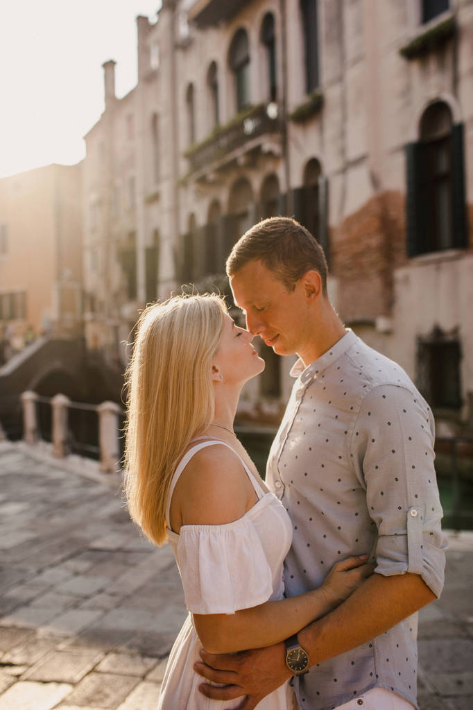 Joven pareja hermosa chica en vestido hombre en camisa blanca caminar por las calles de Venecia Italia
 - Foto, imagen