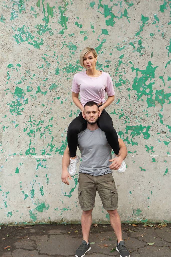 Een meisje zit op de schouders van een vent, Oefeningen met het eigen gewicht - Foto, afbeelding