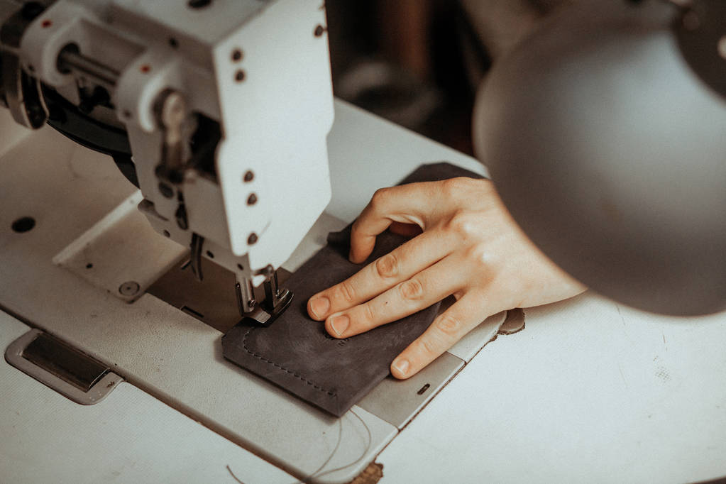 Cierre de la máquina de coser parte de trabajo con cuero. Las manos maestras cosen un producto de cuero. Concepto hecho a mano
. - Foto, imagen