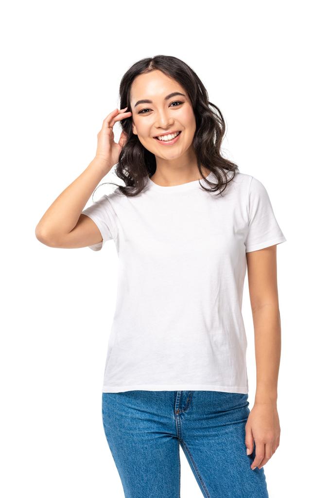 Menina asiática bonita em t-shirt tocando o cabelo isolado no branco
 - Foto, Imagem