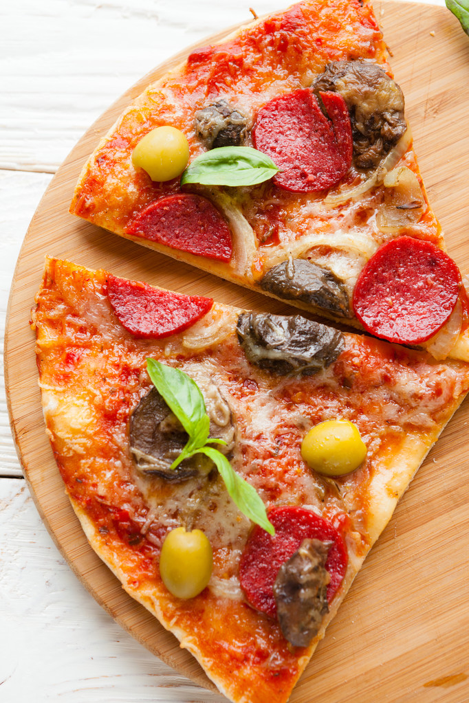 dwie kromki duża pizza z serem, pieczarkami i salami na b - Zdjęcie, obraz