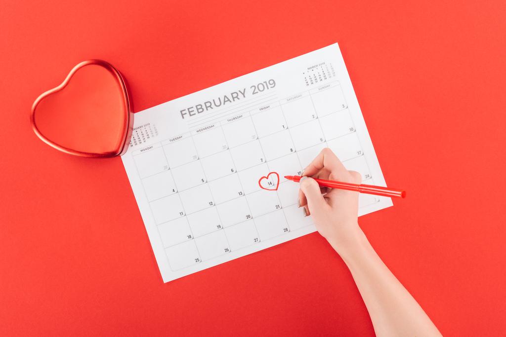obcięty widok kobiety oznakowanie z serca 14 lutego Data w kalendarzu na białym tle na czerwono, st Walentynki koncepcja - Zdjęcie, obraz