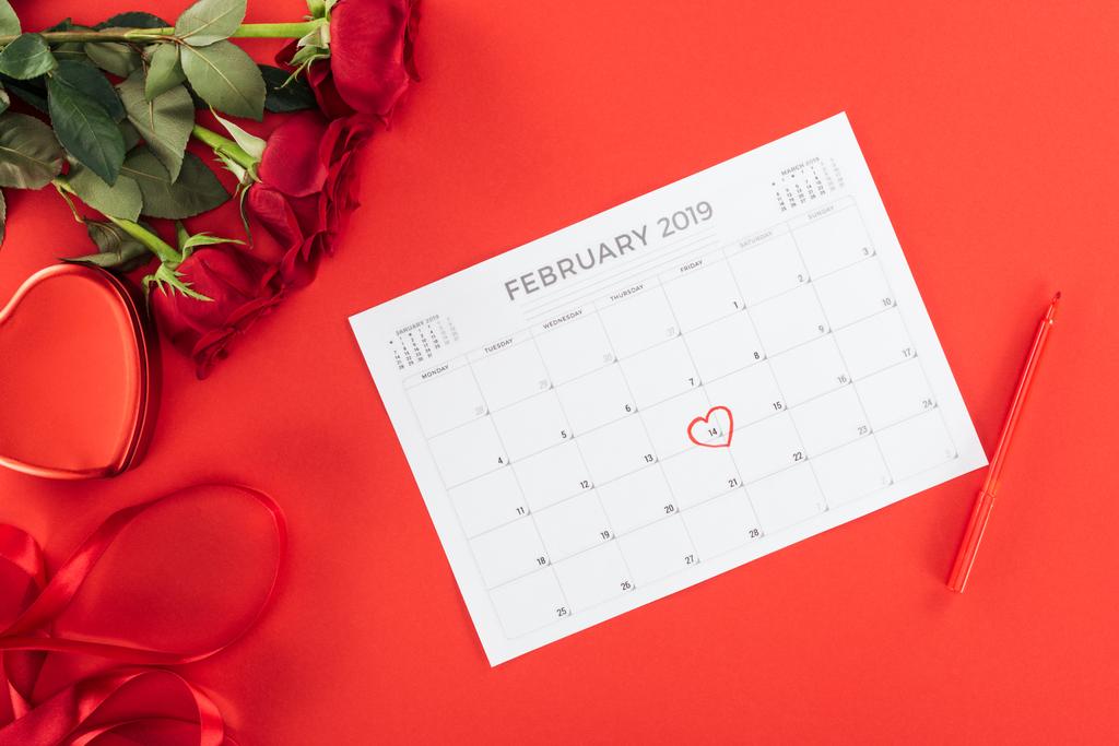 バラと 2 月 14 日の予定表のビューをトップ赤、聖バレンタインの日の概念に分離された心でマークされた日付 - 写真・画像