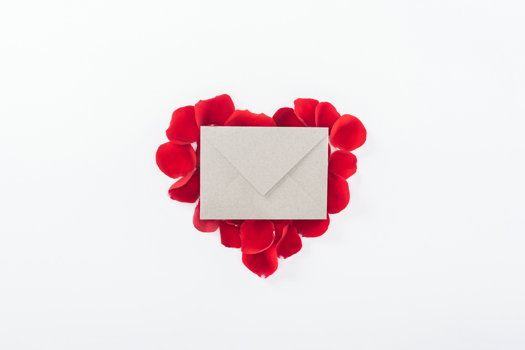 верхний вид конверта и сердца из красных лепестков роз, изолированных на белом, День святого Валентина концепции
 - Фото, изображение