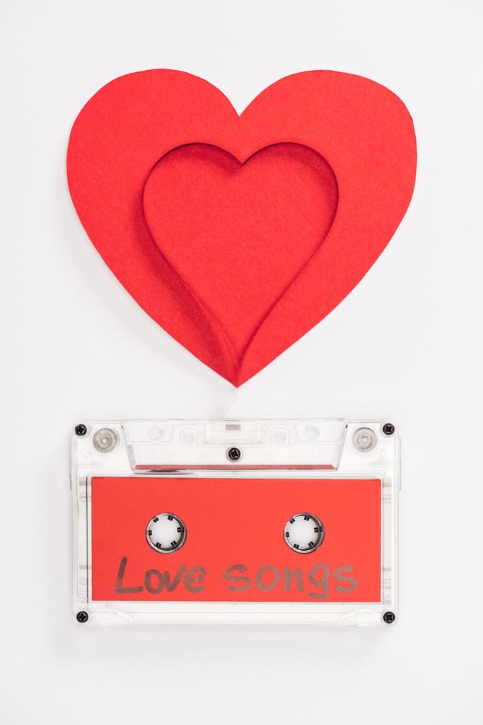 top view of audio cassette with 'love songs' lettering and heart symbols isolated on white, st valentines day concept - Photo, Image