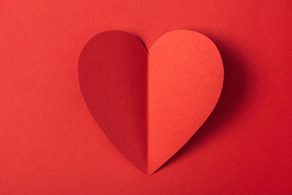 bovenaanzicht van hart gevormde paper kaart geïsoleerd op rood met kopie ruimte, st Valentijnsdag concept - Foto, afbeelding