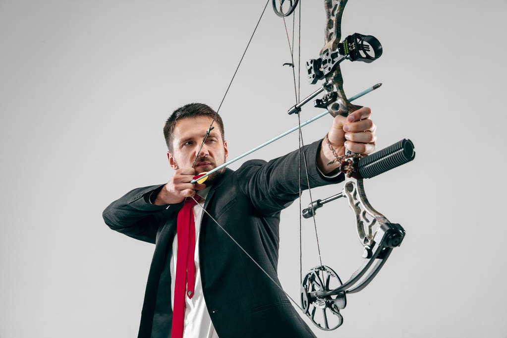 Geschäftsmann zielt mit Pfeil und Bogen auf Ziel, isoliert auf weißem Hintergrund - Foto, Bild