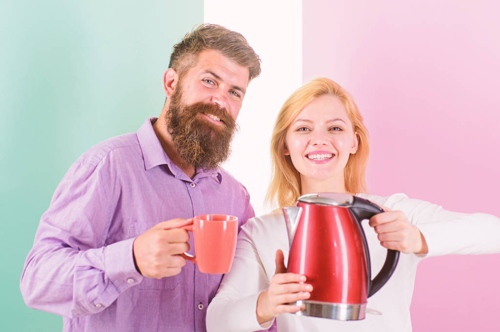First thing they do every morning prepare hot drink. Get energy charge favourite hot drink. Enjoying morning coffee. Man with mug and woman with electric teapot ready to drink morning coffee - Photo, Image