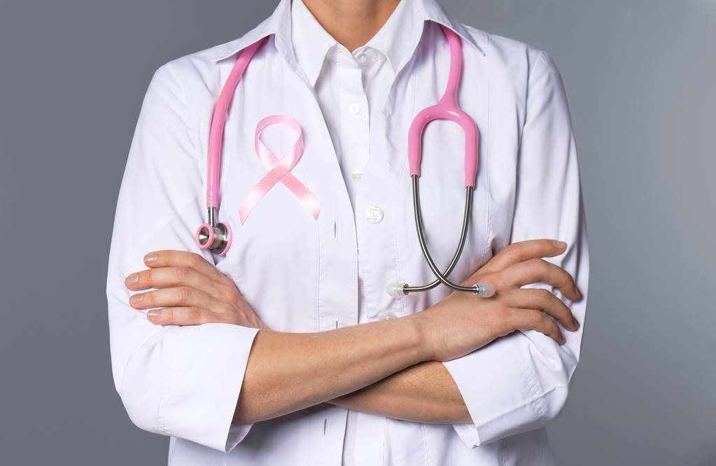 Női orvos rózsaszín szalag és sztetoszkóp, a szürke háttér, közelkép. Mell rák fogalma - Fotó, kép