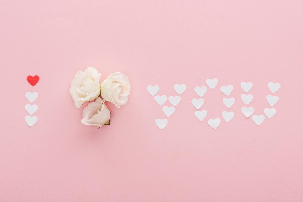pohled shora nápis "Miluji tě", vyrobené z papírové srdce a květiny izolovaných na růžovou, st valentines day koncept - Fotografie, Obrázek