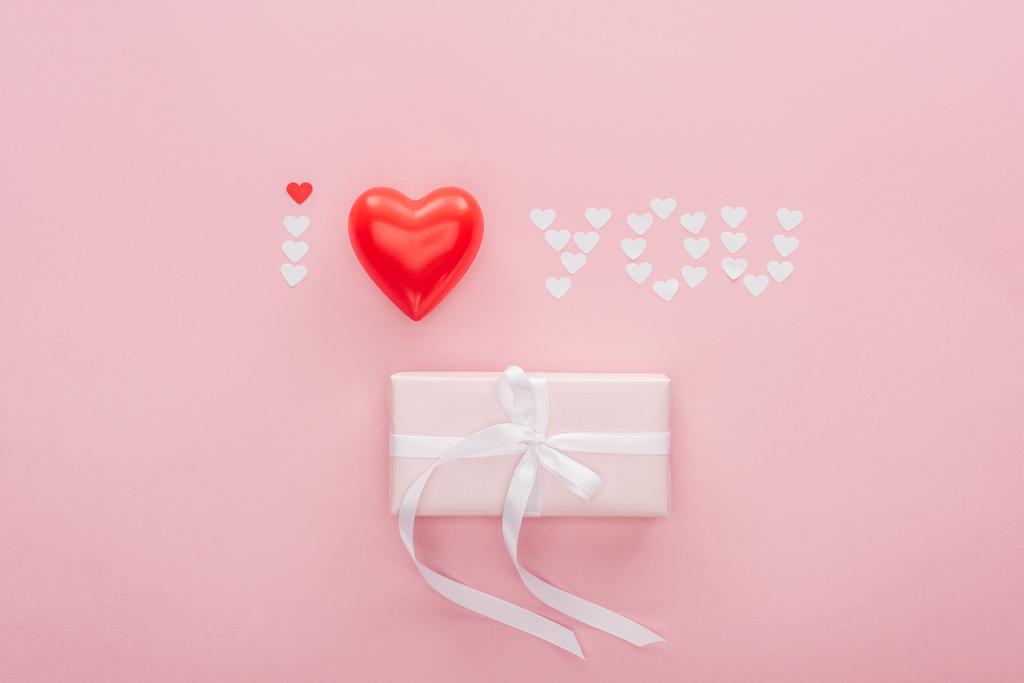 felülnézet díszdobozban és "szeretlek" betűkkel készült papír szívét elszigetelt rózsaszín, Szent Valentin-nap koncepció - Fotó, kép