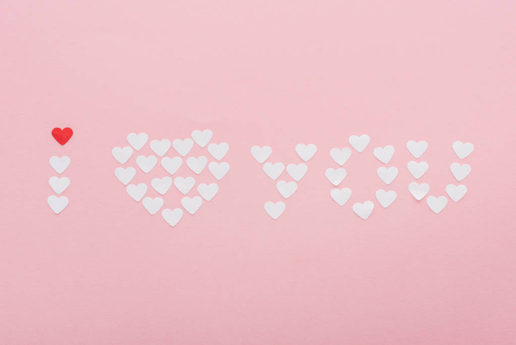 pohled shora "Miluji tě" písma z papírové srdce izolované na růžovou, st valentines day koncept - Fotografie, Obrázek
