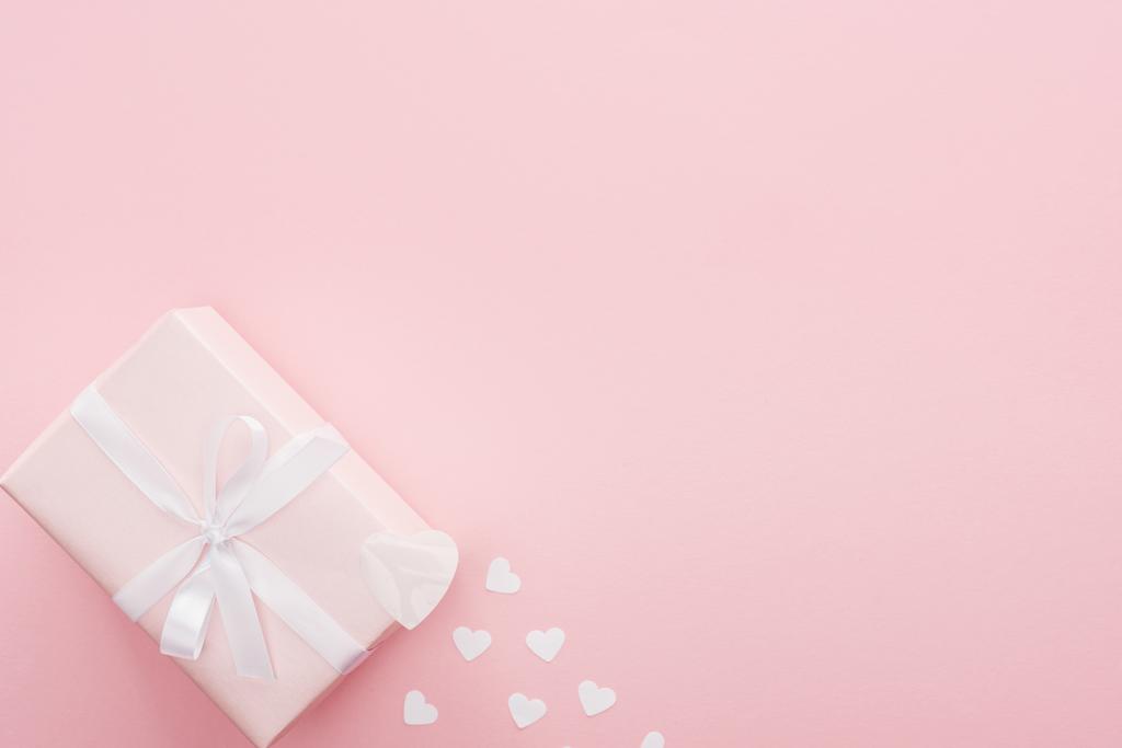 κάτοψη του δώρο κουτί και χαρτί καρδιές που απομονώνονται σε ροζ με αντίγραφο χώρου - Φωτογραφία, εικόνα