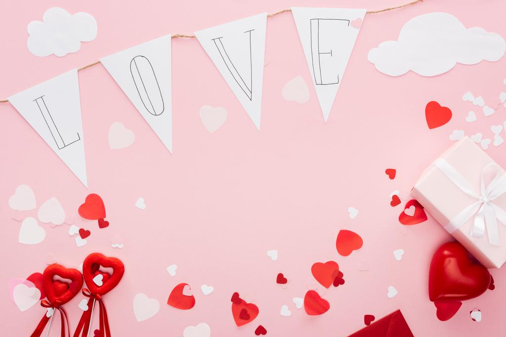Widok z góry Walentynki dekoracje i garland papieru z napisem 'miłość' na białym tle na różowy z kopii przestrzeni, st Walentynki koncepcja - Zdjęcie, obraz