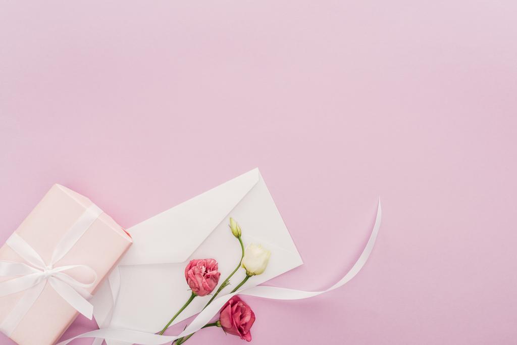 κάτοψη του δώρου, φάκελος και τα λουλούδια που απομονώνονται σε ροζ με αντίγραφο χώρου - Φωτογραφία, εικόνα