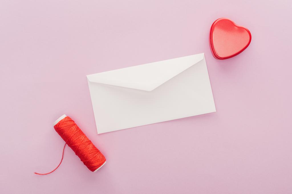 bovenaanzicht van de envelop en hartvormige doos van de gift geïsoleerd op roze, st Valentijnsdag concept - Foto, afbeelding