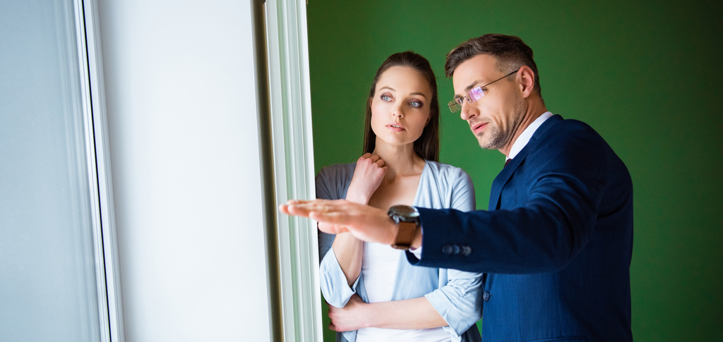 handsome broker showing something to beautiful woman in new home  - Photo, Image