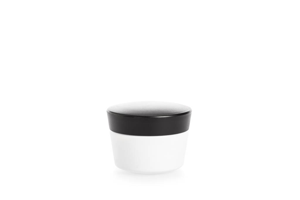 Студійний знімок кремового контейнера з чорною шапочкою ізольовано на білому
 - Фото, зображення