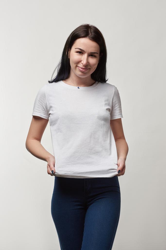 beautiful smiling young woman in white t-shirt with copy space looking at camera isolated on grey - Photo, Image