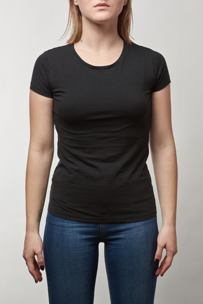 Teilbild einer jungen Frau in lässigem schwarzem T-Shirt mit Kopierraum auf weißem Hintergrund - Foto, Bild