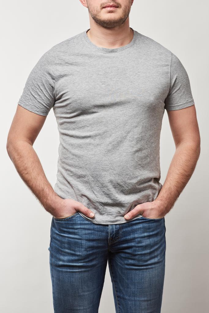 vue partielle de l'homme avec les mains dans les poches en t-shirt avec espace de copie isolé sur gris
 - Photo, image
