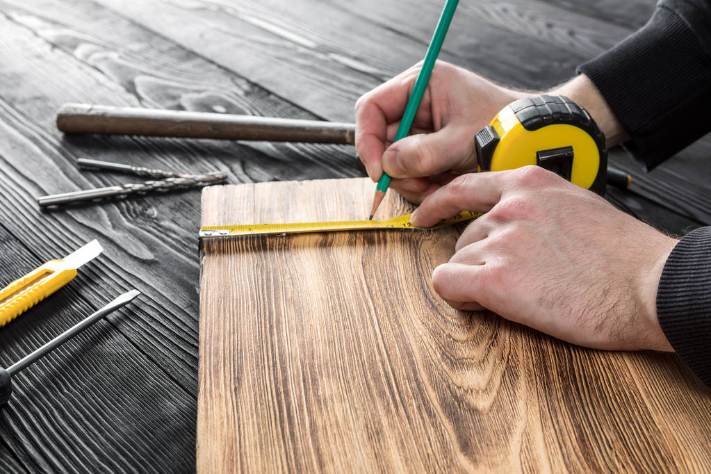 El carpintero trabaja con madera en su espacio de trabajo  - Foto, Imagen