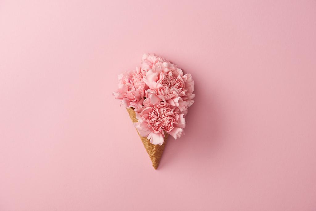 beautiful pink carnation flowers in waffle cone isolated on pink  - Photo, Image
