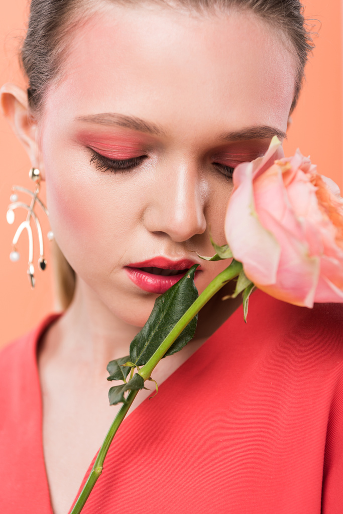 portrait of beautiful stylish girl holding rose and posing isolated on living coral - Photo, Image