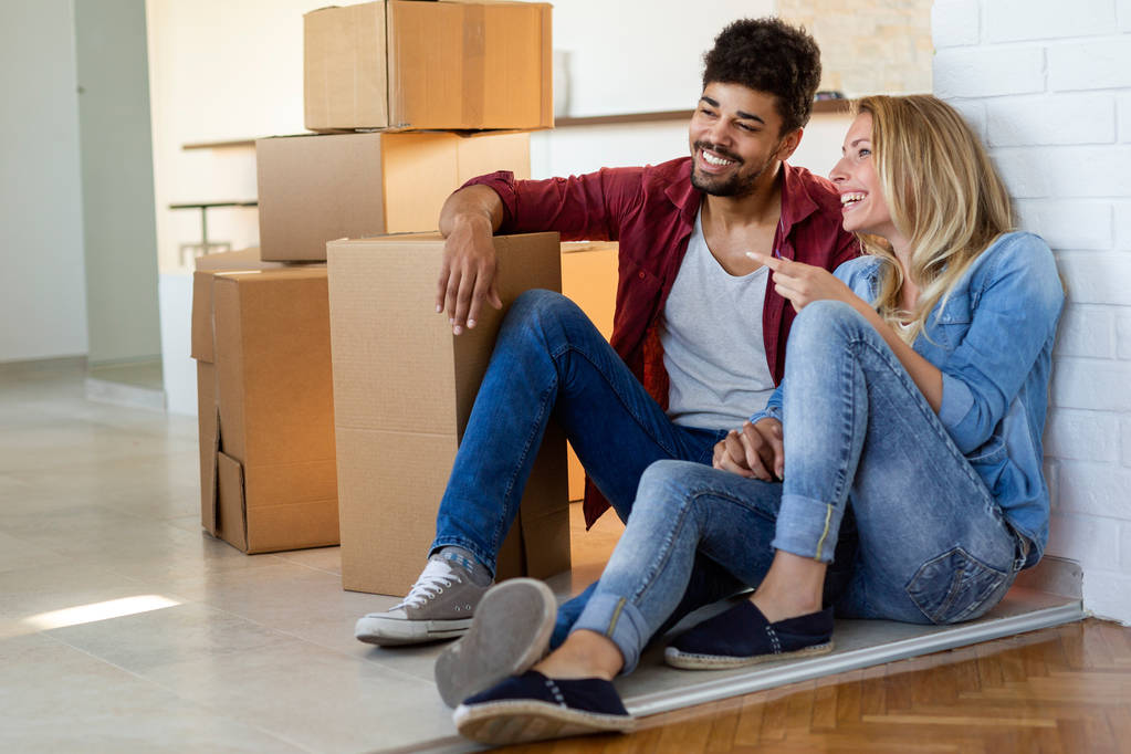 Jeune couple heureux amoureux déménageant dans une nouvelle maison et déballer des boîtes
 - Photo, image