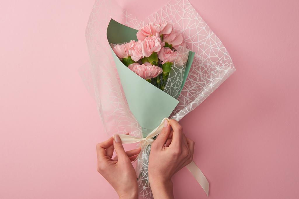 cropped shot of woman tying beautiful tender flower bouquet isolated on pink - Photo, Image