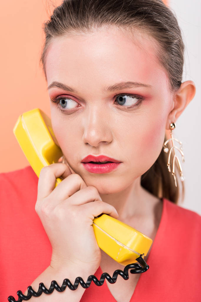 bela menina da moda falando no telefone retro com coral vivo no fundo
 - Foto, Imagem