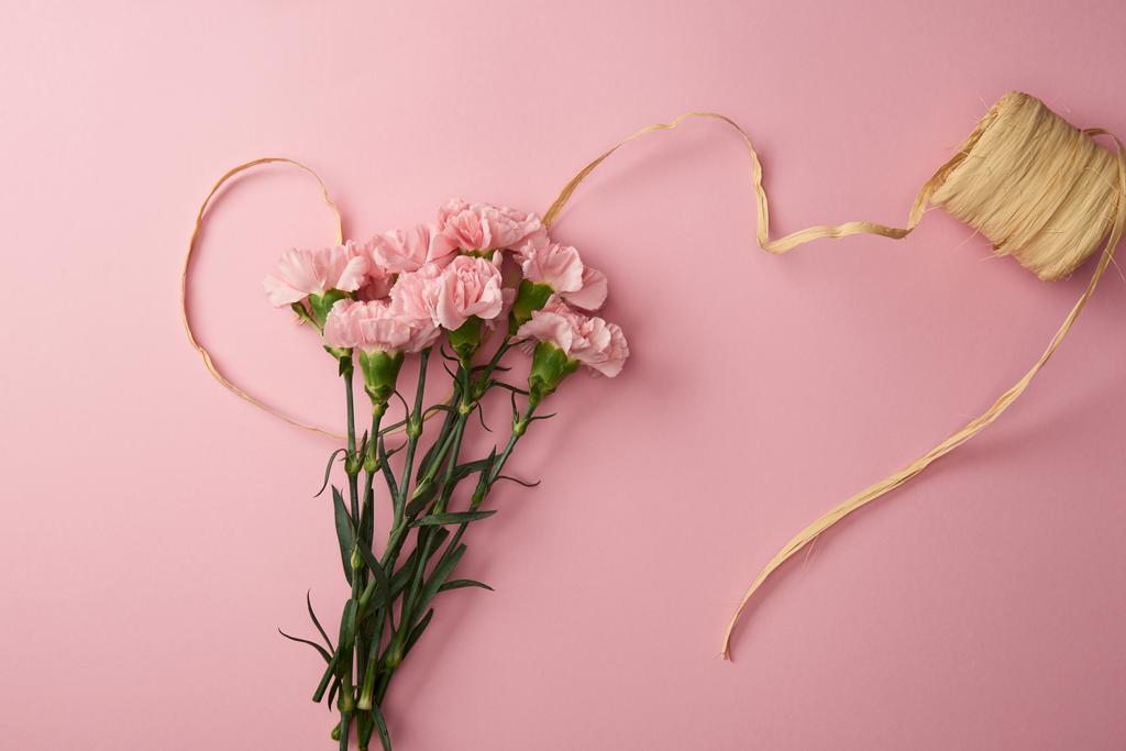 το top view από όμορφα ροζ λουλούδια γαρύφαλλο και απομονώνονται σε ροζ κορδέλα - Φωτογραφία, εικόνα