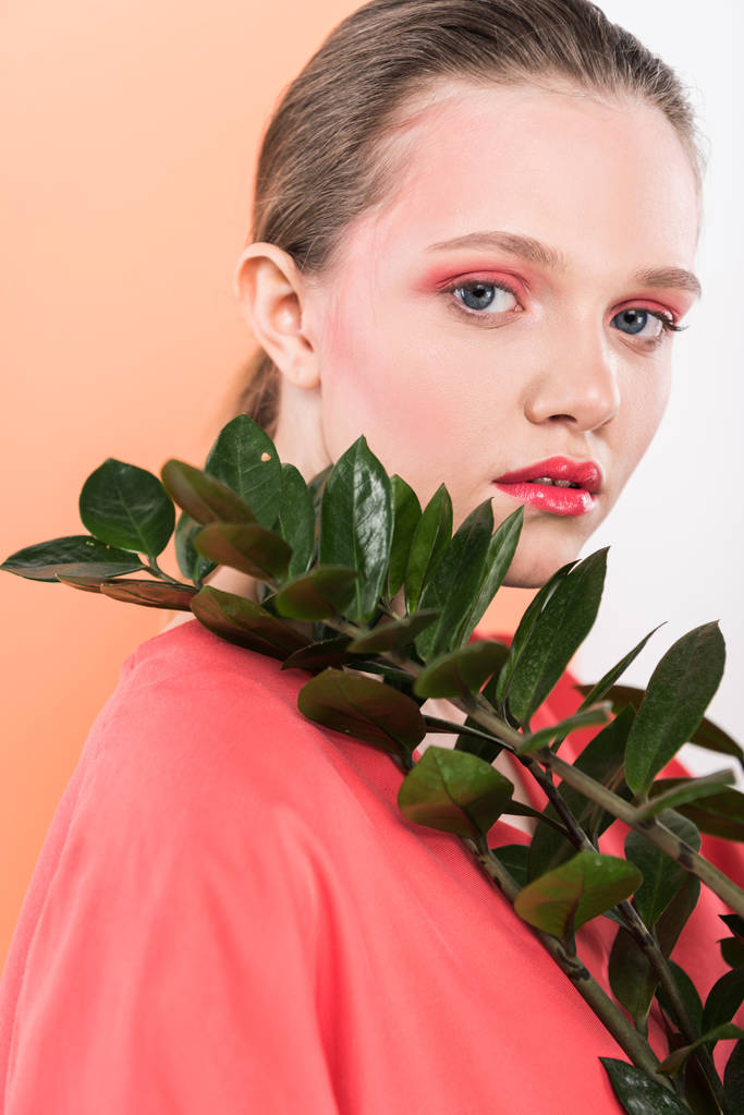 красивая стильная девушка с растением, смотрящая в камеру и позирующая на фоне живых кораллов
 - Фото, изображение
