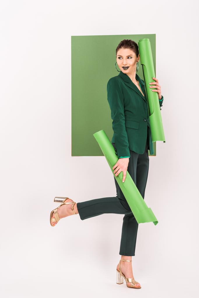 beautiful stylish woman holding paper rolls and posing with sea green on background - Photo, Image