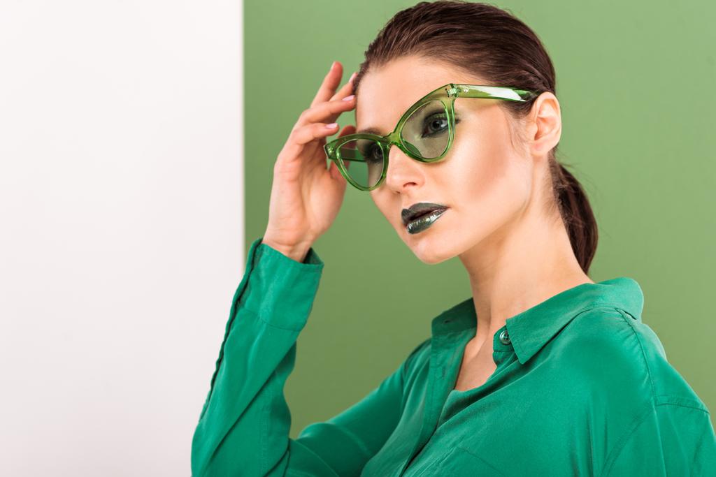 gyönyörű divatos nő napszemüveg jelentő és keres el a tenger zöld háttér - Fotó, kép