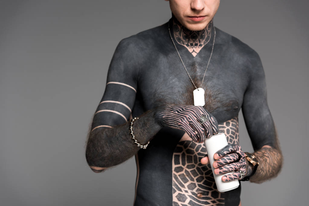 bijgesneden schot van shirtless tattooed man openen aluminium kan geïsoleerd op grijs - Foto, afbeelding