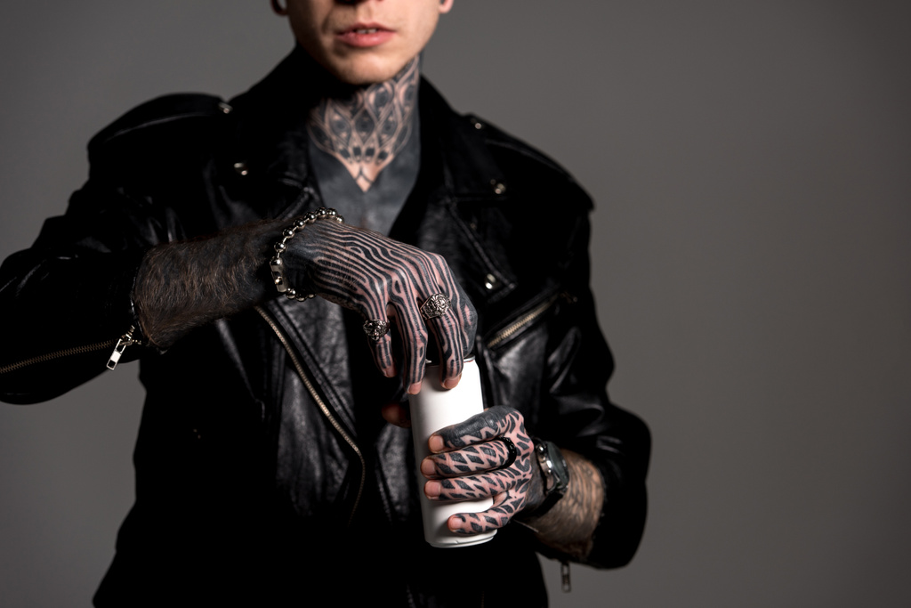 cropped shot of tattooed man in leather jacket opening soda can isolated on grey - Photo, Image